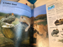 Load image into Gallery viewer, Open book showing a dinosaur and lions with educational text and illustrations on a table.